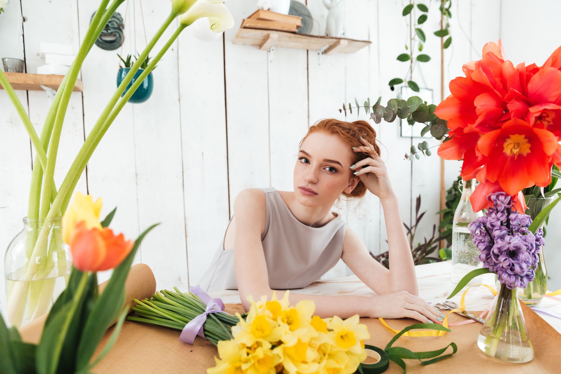 tired-young-woman-florist-gazing-at-camera-while-P6K7PK7.jpg